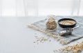 Oatmeal in a jar and in a bowl on a napkin on a white textured table in front of the kitchen window Royalty Free Stock Photo