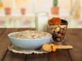 Oatmeal, milk, nuts, dried fruit on background of kitchen. Royalty Free Stock Photo