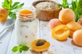 Oatmeal milkshake, smoothie or yogurt with fresh apricot on a white wooden table