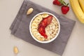 Oatmeal muesli in a bowl with strawberries, banana and flax seeds. Healthy breakfast.