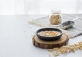 Oatmeal in a plate and in a jar on a napkin on a white textured table in front of the kitchen window Royalty Free Stock Photo