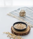 Oatmeal in a plate and in a jar on a napkin on a white textured table in front of the kitchen window Royalty Free Stock Photo