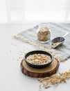 Oatmeal in a plate and in a jar on a napkin on a white textured table in front of the kitchen window Royalty Free Stock Photo