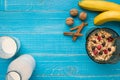 Oatmeal porridge with banana, kiwi fruit, nuts and honey in a bowl with egg for healthy breakfast on rustic wooden Royalty Free Stock Photo