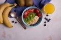 Oatmeal porridge with berries, strawberry, banana and kiwi in bowl on background Royalty Free Stock Photo