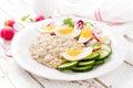 Oatmeal porridge with boiled egg and vegetable salad with fresh radish, cucumber and lettuce. Healthy dietary breakfast Royalty Free Stock Photo