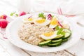 Oatmeal porridge with boiled egg and vegetable salad with fresh radish, cucumber and lettuce. Healthy dietary breakfast Royalty Free Stock Photo