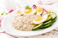 Oatmeal porridge with boiled egg and vegetable salad with fresh radish, cucumber and lettuce. Healthy dietary breakfast