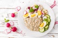 Oatmeal porridge with boiled egg and vegetable salad with fresh radish, cucumber and lettuce. Healthy dietary breakfast Royalty Free Stock Photo