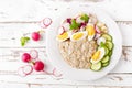 Oatmeal porridge with boiled egg and vegetable salad with fresh radish, cucumber and lettuce. Healthy dietary breakfast Royalty Free Stock Photo