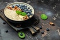 Oatmeal porridge in a bowl with fresh blueberries and nuts on a dark table. Healthy breakfast. Super food healthy eating Royalty Free Stock Photo