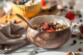 Oatmeal porridge in coconut bowl with wooden spoon. Porridge oats with strawberry, pistachios, blueberry, almond and