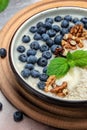 Oatmeal porridge with ripe blueberries, nuts and honey healthy breakfast on rustic wooden background. close up Royalty Free Stock Photo