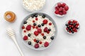 Oatmeal porridge with summer raspberry, currant berries,honey. Porridge oats in bowl with fruits. Healthy food breakfast