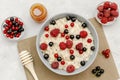 Oatmeal porridge with summer raspberry, currant berries,honey. Porridge oats in bowl with fruits. Healthy food breakfast