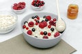 Oatmeal porridge with summer raspberry, currant berries,honey. Porridge oats in bowl with fruits. Healthy food breakfast