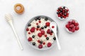 Oatmeal porridge with summer raspberry, currant berries,honey. Porridge oats in bowl with fruits. Healthy food breakfast,lifestyle