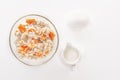 Oatmeal with pumpkin and nuts, egg and jug of milk on a white background. Royalty Free Stock Photo