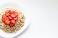 oatmeal with strawberries on a white plate, copy space