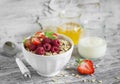 Oatmeal with summer berries - raspberries, strawberries, honey and yogurt in a white bowl