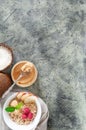 Oatmeal in a white plate with peanut butter, raspberries, apple slices and mint. Near a jar of peanut butter. Coconuts and a spoon Royalty Free Stock Photo