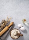 Oatmeal in a wooden bowl with eggs, oli and rolling pin on a blue background. Natural organic flour for home baking