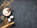 Oatmeal in a wooden bowl with eggs, rolling pin and oli on a dark blue background. Natural organic flour for home baking