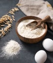 Oatmeal in a wooden bowl with a scoop on a dark blue background with eggs and dry branches oats. Organic ingredients for baking Royalty Free Stock Photo