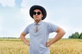 Oats plant. Harvester. Portrait of farmer standing in gold wheat field with blue sky in background. Young man wearing Royalty Free Stock Photo