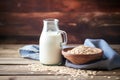 oats scattered on a vintage wooden table with oat milk jug in blurred background Royalty Free Stock Photo