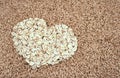 Oats seeds and oat-flakes heart Royalty Free Stock Photo