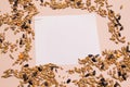 Oats, wheat, corn, sunflower seeds and white blank note paper on pink background.