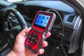 OBD2 scanner in hand, car diagnostic tool and code reader to check engine light, read and clear DTCs Royalty Free Stock Photo