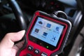 OBD2 scanner in hand, car diagnostic tool and code reader to check engine light, read and clear DTCs Royalty Free Stock Photo