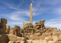 An obelisk and many stone columns in the ancient temple of Karnak in the Egyptian city of Luxor. In the foreground are many stones Royalty Free Stock Photo