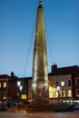 The Obelisk in Richmond Market Place, North Yorkshire in the glow of late evening light with deep blue sky in the background