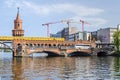 Oberbaum Bridge with an U-Bahn train crossing it and new building lot with cranes in Berlin Royalty Free Stock Photo