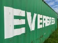 Closeup of one old isolated green evergreen marine container on grass, lettering with diminishing perspective