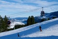 OBERSTAUFEN, GERMANY - 31 DEC, 2017: Ski lift with gondola and ski slope and skiers in the foreground