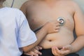 Obese asian boy check heart by stethoscope