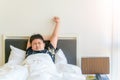 Obese boy wake up and stretch arm on bed in morning Royalty Free Stock Photo