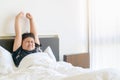 Obese boy wake up and stretch arm on bed in morning. lazy and rest Royalty Free Stock Photo