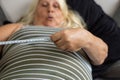An obese elder women is shocked after looking at the numbers shown with the measuring tape