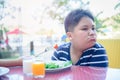 Obese fat boy with expression of disgust against vegetables Royalty Free Stock Photo