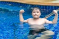 Obese fat boy show muscle in swimming pool Royalty Free Stock Photo