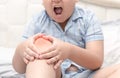 Obese fat boy suffering from knee pain and sit on bed Royalty Free Stock Photo