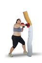 Obese female boxer punching a cigarette
