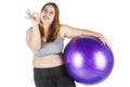 Obese female showing ok sign with fitness ball