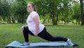 Obese girl stretches in park, daily routine for losing weight, desire to be slim