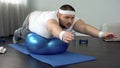 Obese hardworking man practicing static exercise, strength training program